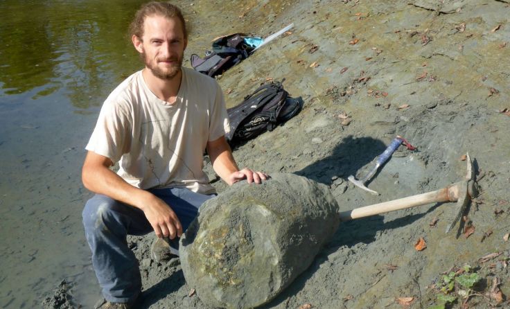 Finder Felix Hofmayer mit dem im Gestein verborgenen Delfinschädel. Foto: H.-G. Krenmayr