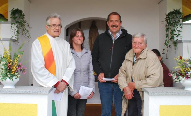 Pfarrassistent Konrad Siebert mit der Familie Reitinger. (Foto: Dallinger)