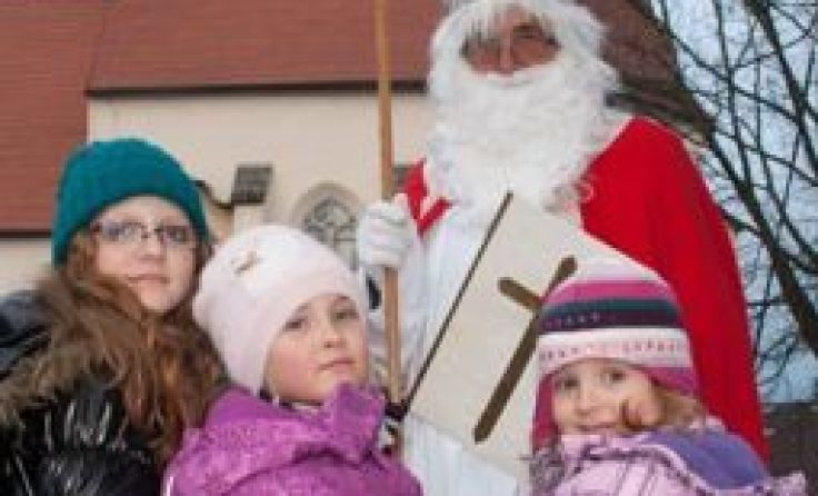 Der Nikolaus kommt mit der Pferdekutsche und verteilt Geschenke.