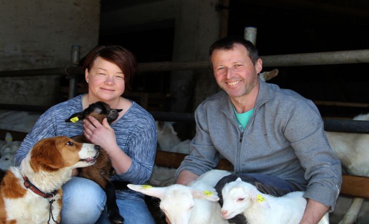 Christian und Lucia Koller , umgeben von den Zicklein, den Ziegen und dem Hirtenhund Walli.