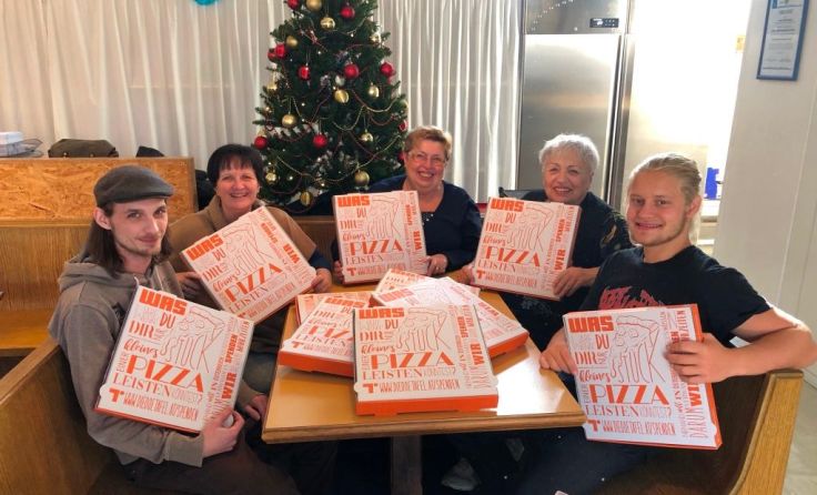 Teammitglieder der OÖ Tafel mit den bedruckten Pizzaschachteln. Foto: ooetafel