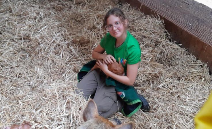 Lehrling Pia kümmert sich um ein Kune-Kune Ferkel. (Foto: privat)