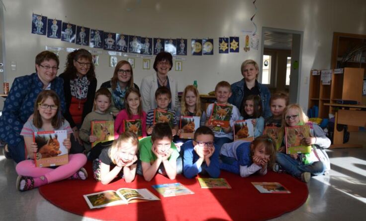  Die Kinder freuen sich über ihre neuen Bücher.