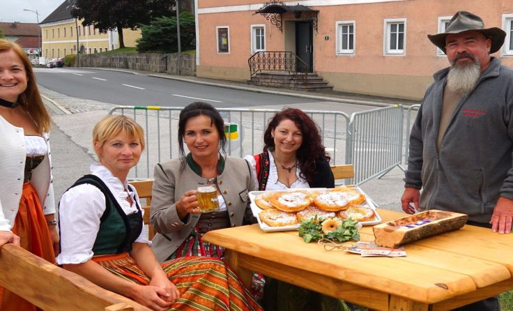 Die Bäuerinnen aus dem Ort bieten frische Krapfen an.
