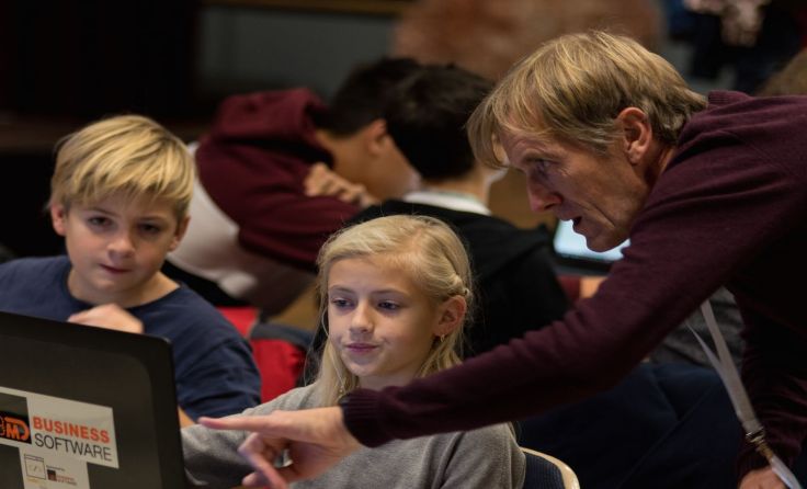 Ehrenamtliche Mentoren helfen den Kindern beim Programmieren. Foto: Tobias Zachl