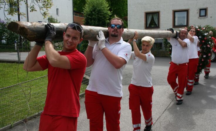 Die Rot Kreuz Mitarbeiter bringen den frisch geschmückten Maibaum zurück
