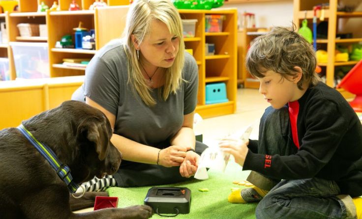 Caritas-Sonderkindergartenpädagogin Sandra Kainzinger mit Joey und Luan (Foto: Caritas)