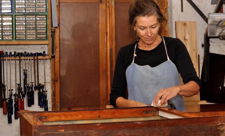 Renate Obermayr-Aigner mit einem von ihr restaurierten Möbelstück