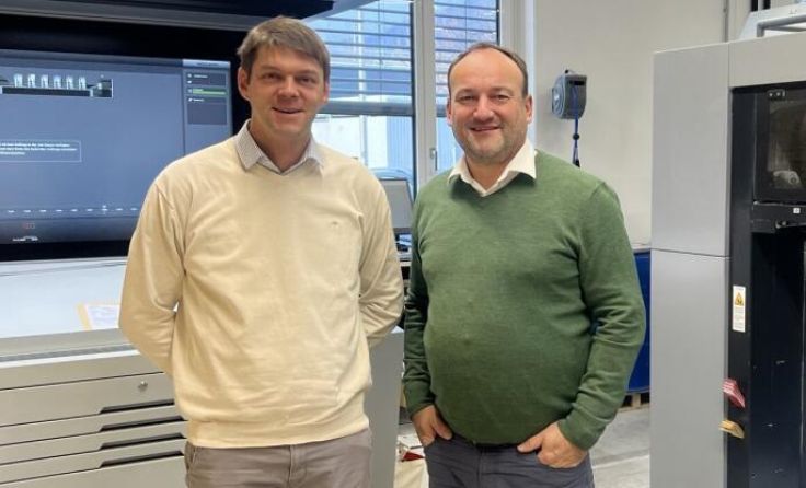 Mathias Schrabacher und Daniel Fürstberger vor der neuen Druckmaschine (Foto: Fürstberger)