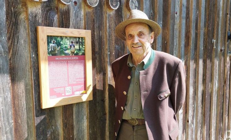 Fritz Wolf vor der Waldschule, der QR-Code führt zum digitalen Infoguide. (Foto: Tóth)