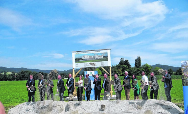 Bei sommerlichen Temperaturen nehmen die Ehrengäste voller Enthusiasmus den Spatenstich vor.
