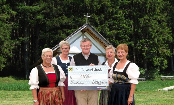 Pater Franz Schmalwieser nimmt den Scheck entgegen.
