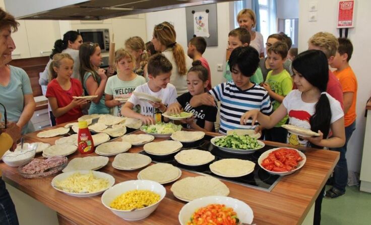 Die Kinder bereiten gemeinsam die Speisen zu.