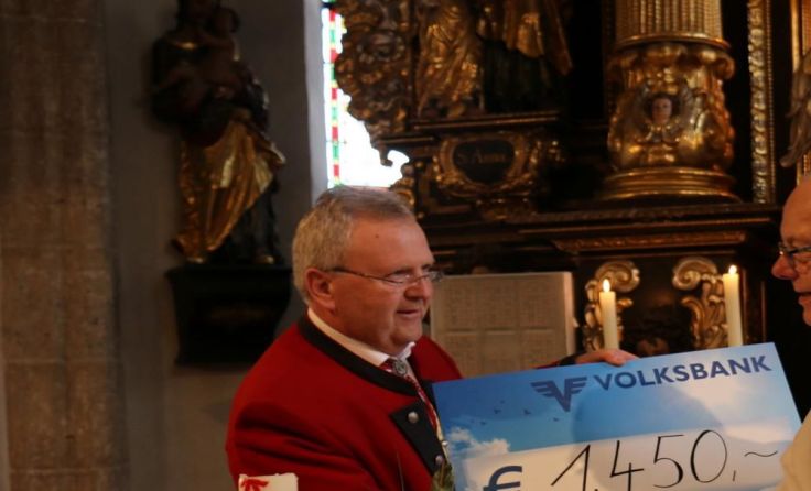Karl Rauscher übergibt den Scheck an Pfarrer Wolfgang.