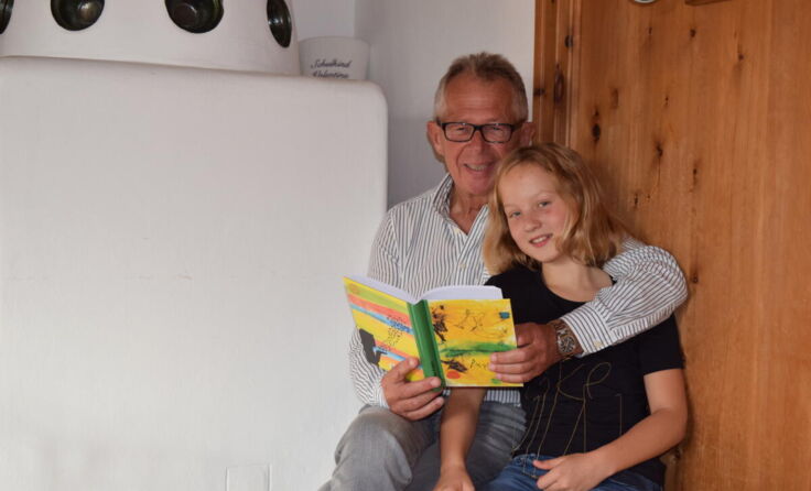 Reinhard Burgstaller liest seiner Enkelin Valentina aus dem neuen Buch Geschichten vor. (Foto: Ertl)