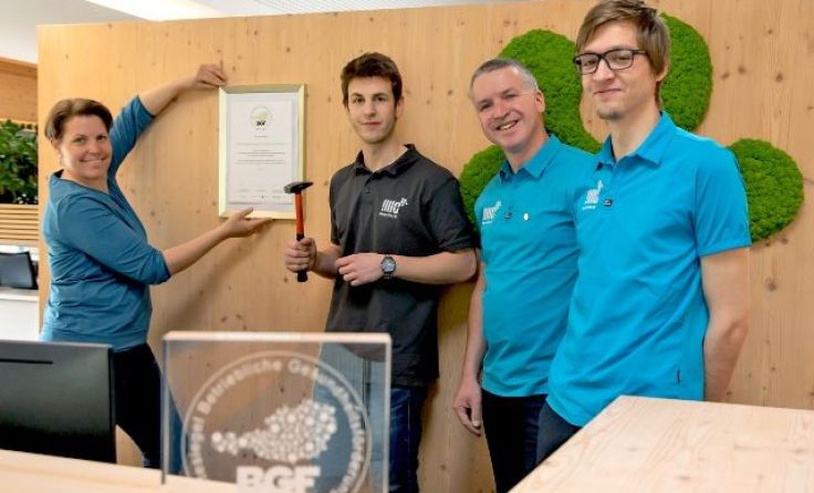 Das IMC-Team hängt gemeinsam das BGF-Siegel auf, um an Wertschätzung zu erinnern.