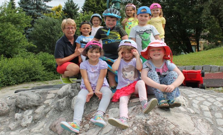 Kindergartenleiterin Sabine Kalchmayr (l.) mit einigen Kindern im Garten, Foto: Egelseder