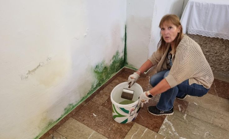 Obfrau Leopoldine Berger beseitigt den Schimmel an der Kirchenmauer. (Foto: privat)