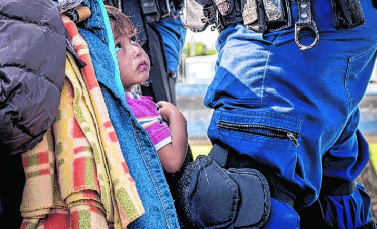 Ein Flüchtlingskind in Röszke vor ungarischen Polizisten Foto: Christopher Glanzl