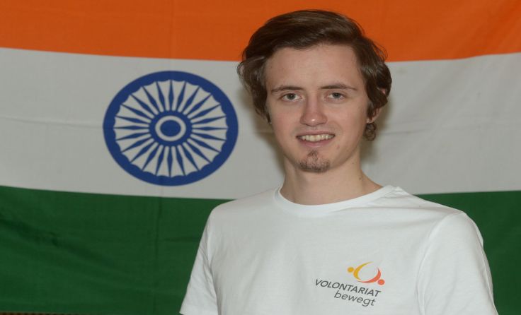 Jonathan Böhm. Im Hintergrund die Flagge Indiens. Foto: kathpress.at/ Franz Josef Rupprecht
