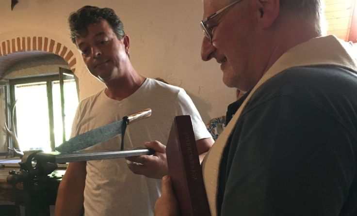 Klaus Reitermayr übergibt das Messer an Pfarrer Franz Schauer. Foto: Lackner