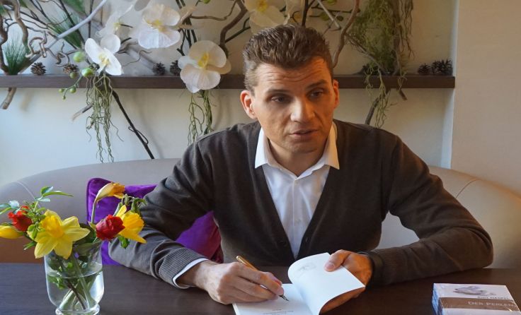 Der Autor beim Signieren seines Romans.