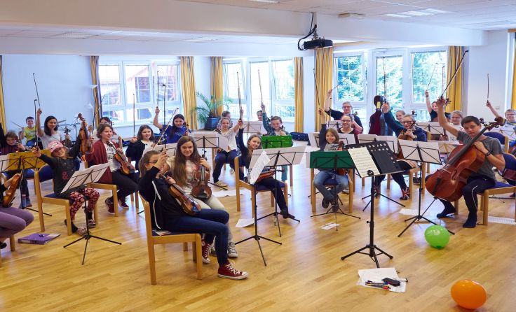 Ein Streichorchester, ein Jugendblasorchester, eine Big-Band und ein großer Chor sind zu hören.