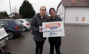Junge Familie beim Einkaufen vom Glücksengerl beschenkt