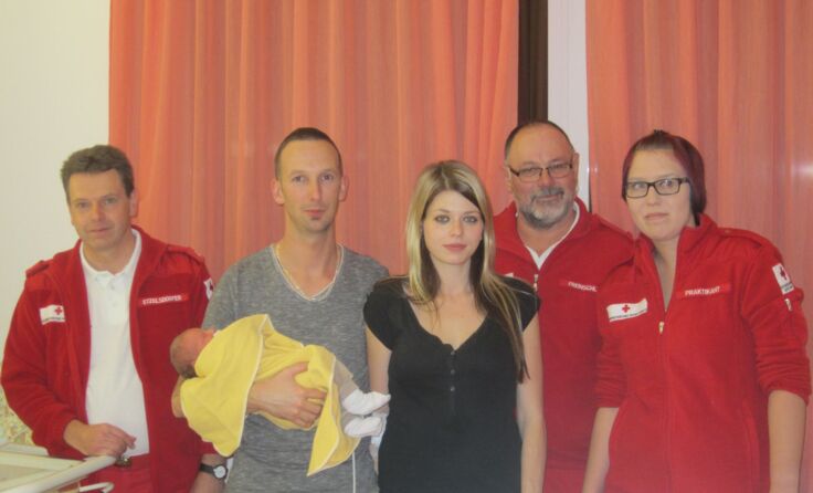 Der kleine Niklas mit seinen Eltern und dem Team vom Roten Kreuz