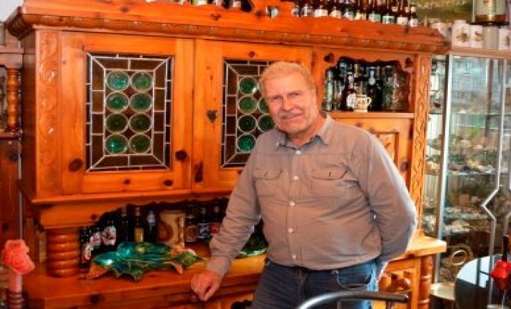 Karl Tröstl vor der Zirbenholz-Kredenz
