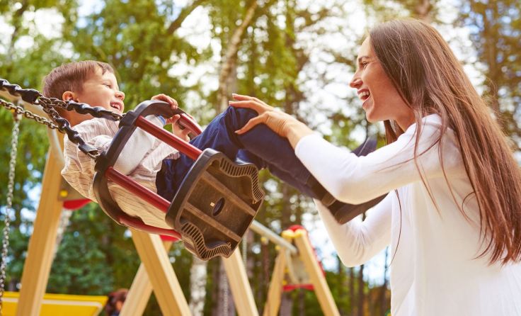 Glückliche Mutter und lachender Sohn beim Schaukeln. Foto: ArtFamily