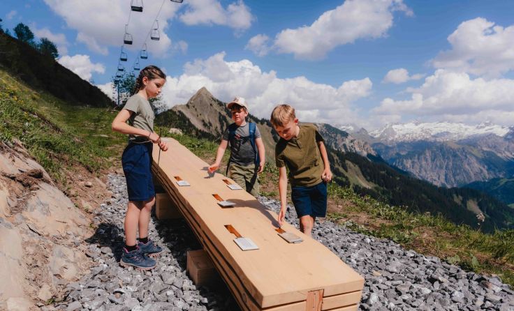 Kinder an einer Spielstation des Murmelwegs in Faschina (Foto: Alpenregion Bludenz Tourismus)