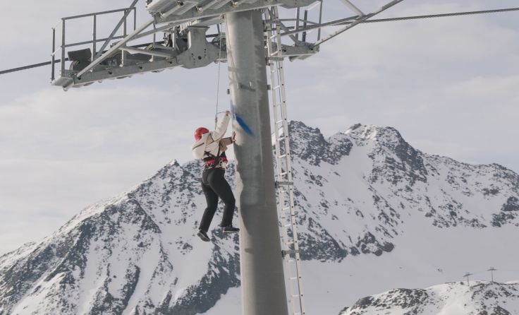Hannah Philomena Scheiber hängt am Seil und bemalt Liftstützen (Foto: Flo Mitteregger)