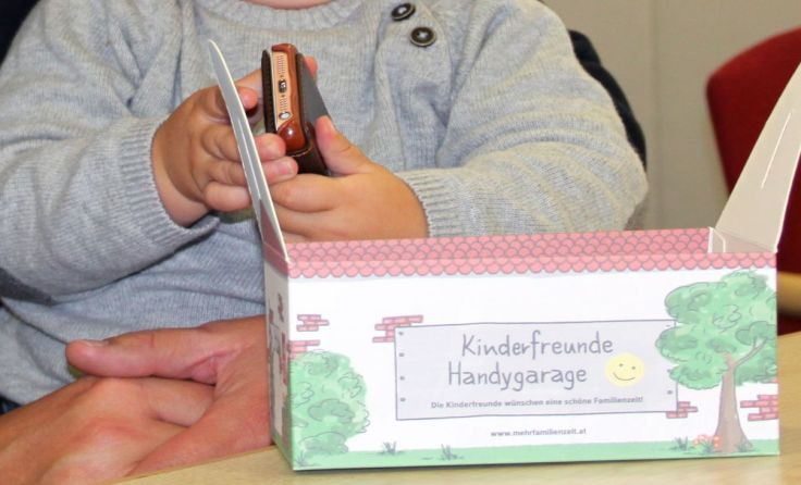 Landesvorsitzender Roland Schwandner mit Sohn Theo und der Handygarage. Foto: Kinderfreunde OÖ