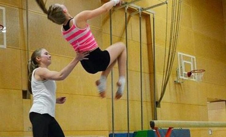Julia Piereder unterstützt eine junge Turnerin beim Training.