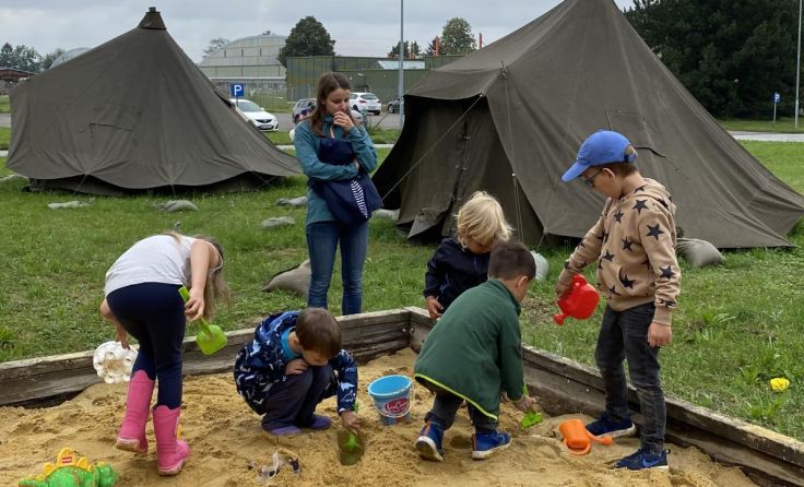 Kinder spielen im draußen im Sandkasten, Betreuerin Anja Geier (Foto: Militärkommando OÖ)