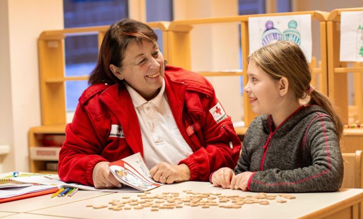 Lesecoach Claudia Hofmann mit einem ihrer Lesekinder. (Foto: OÖRK/Angelika Tröbinger)
