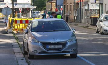 Bauzaun stürzt in Wels um und beschädigt Auto